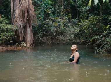 Neidinha Bandeira, ativista ambiental, toma banho em um rio na floresta amazônica (Crédito: Alex Pritz/Amazon Land Documentary)