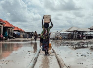 Milhões estão deslocados em toda a Nigéria devido a conflitos, impactos das alterações climáticas e catástrofes naturais. Nesta foto de arquivo, uma menina leva água para seu abrigo em um campo de deslocados internos no nordeste do país