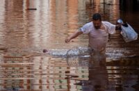 Um homem atravessa enchentes em Porto Alegre, Rio Grande do Sul, Brasil