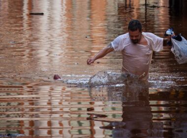 Um homem atravessa enchentes em Porto Alegre, Rio Grande do Sul, Brasil